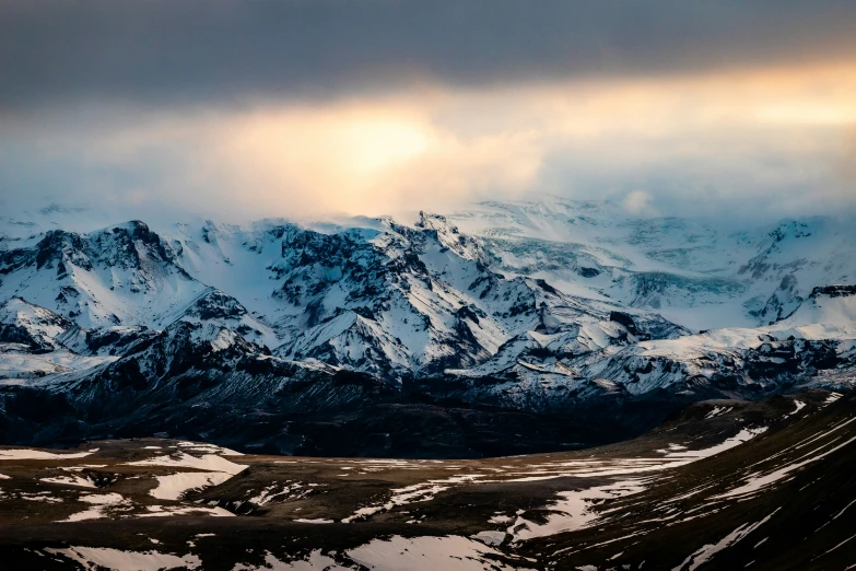 snow covered mountains are shown under stormy skies