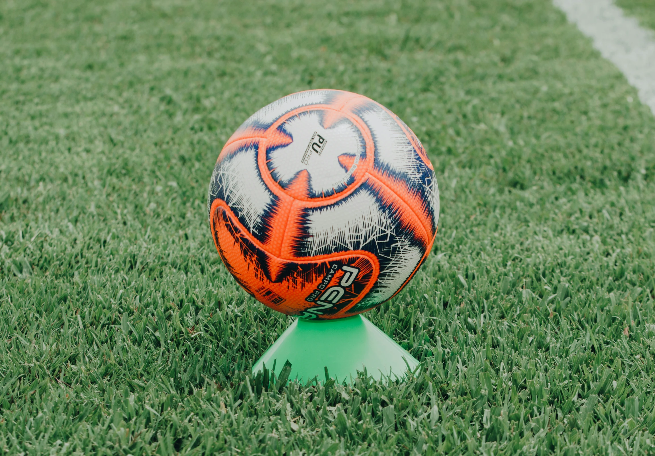 a soccer ball sits on top of a post in the grass