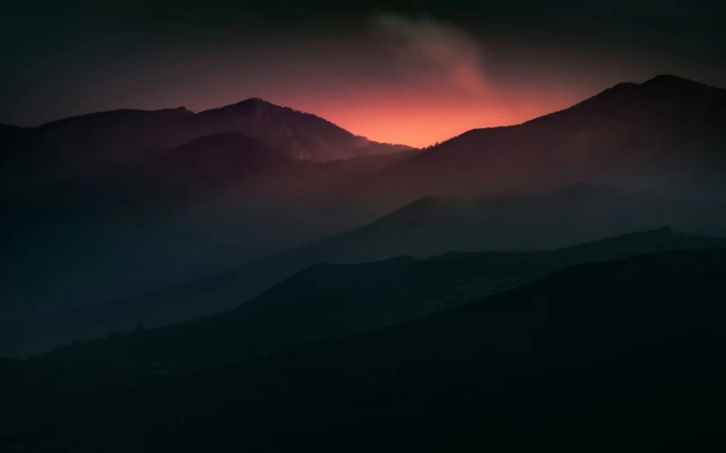 a dark mountain range that looks like the mountains are on fire