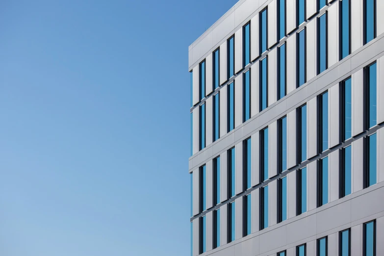 a tall gray building with lots of windows next to another one