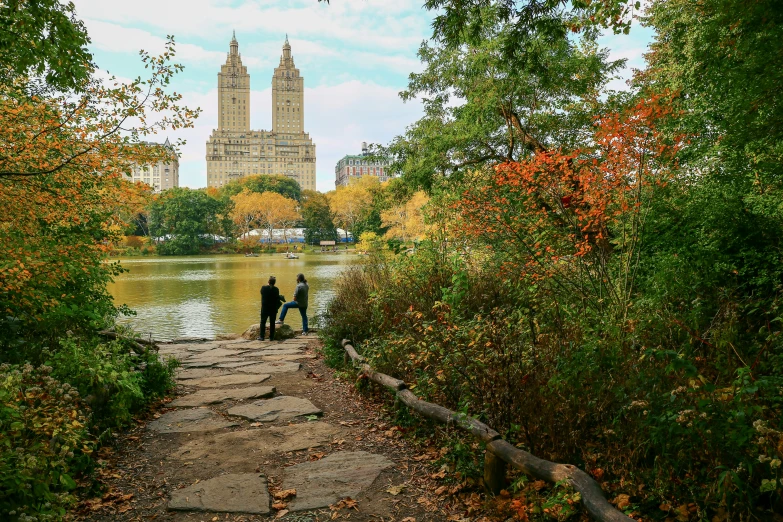 two people walking up a path towards a lake