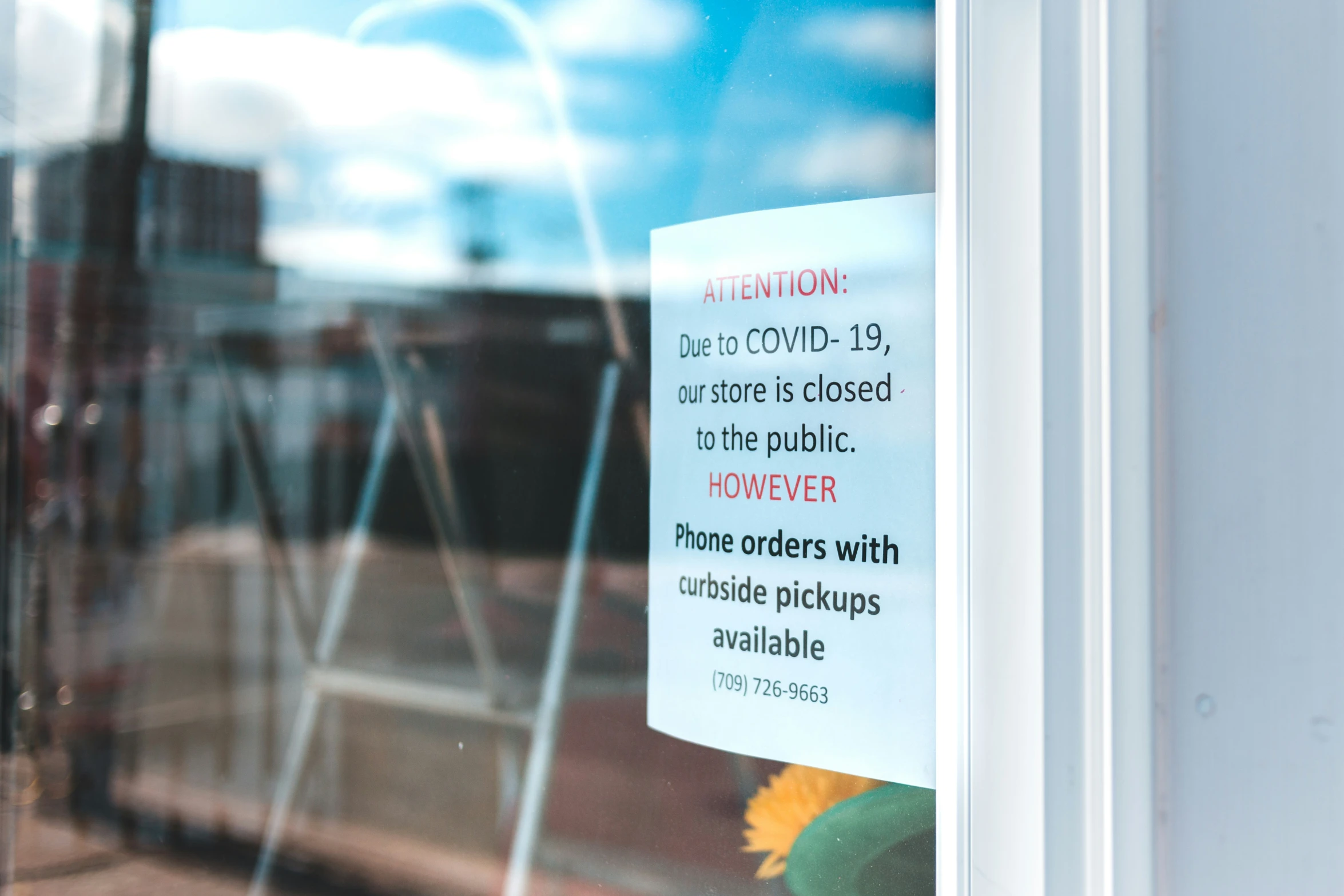 a sign on a window with an image of a flower in the window