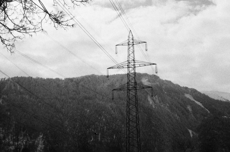 an array of power lines and telephone poles in front of mountains