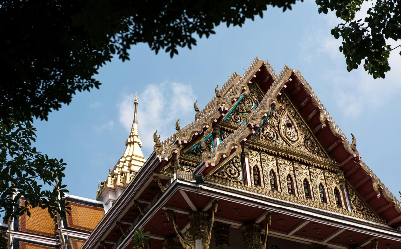 an elaborate gilded, ornately decorated temple stands in a garden