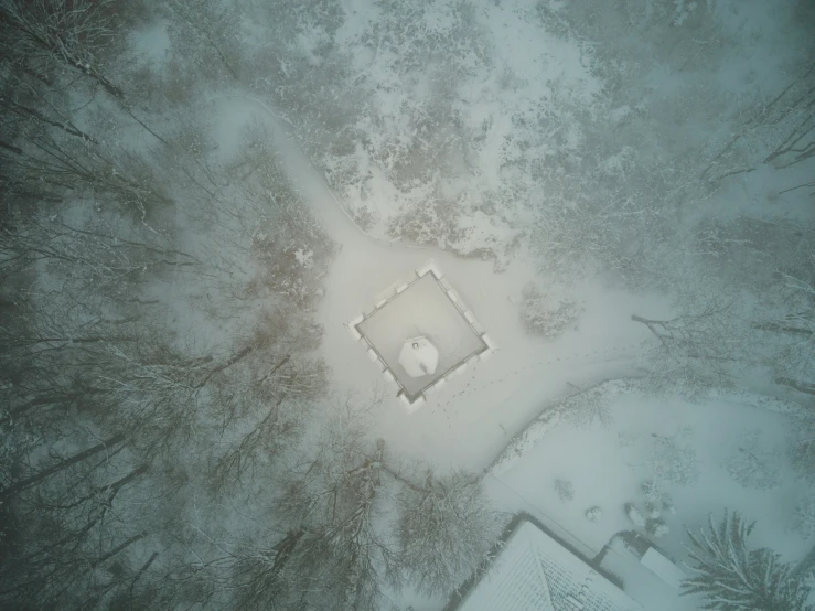 view from the air of a snowy area with a house and tree nches