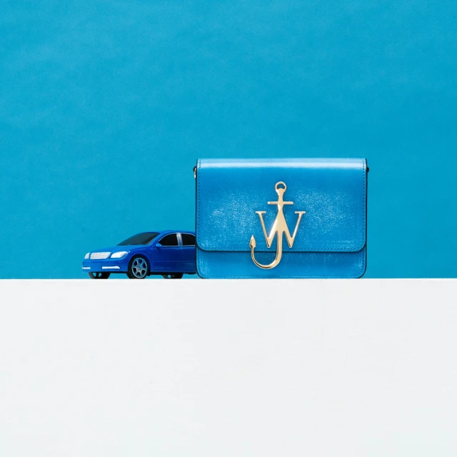 a car is parked beside a blue purse