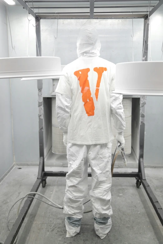 a man with a protective suit is standing in front of a machine