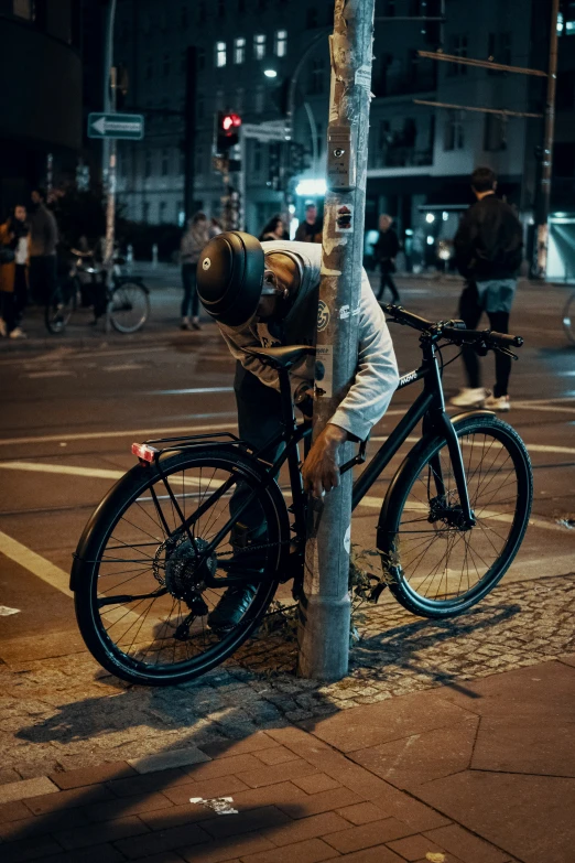 a bicycle parked against the tree is  to the side of the pole