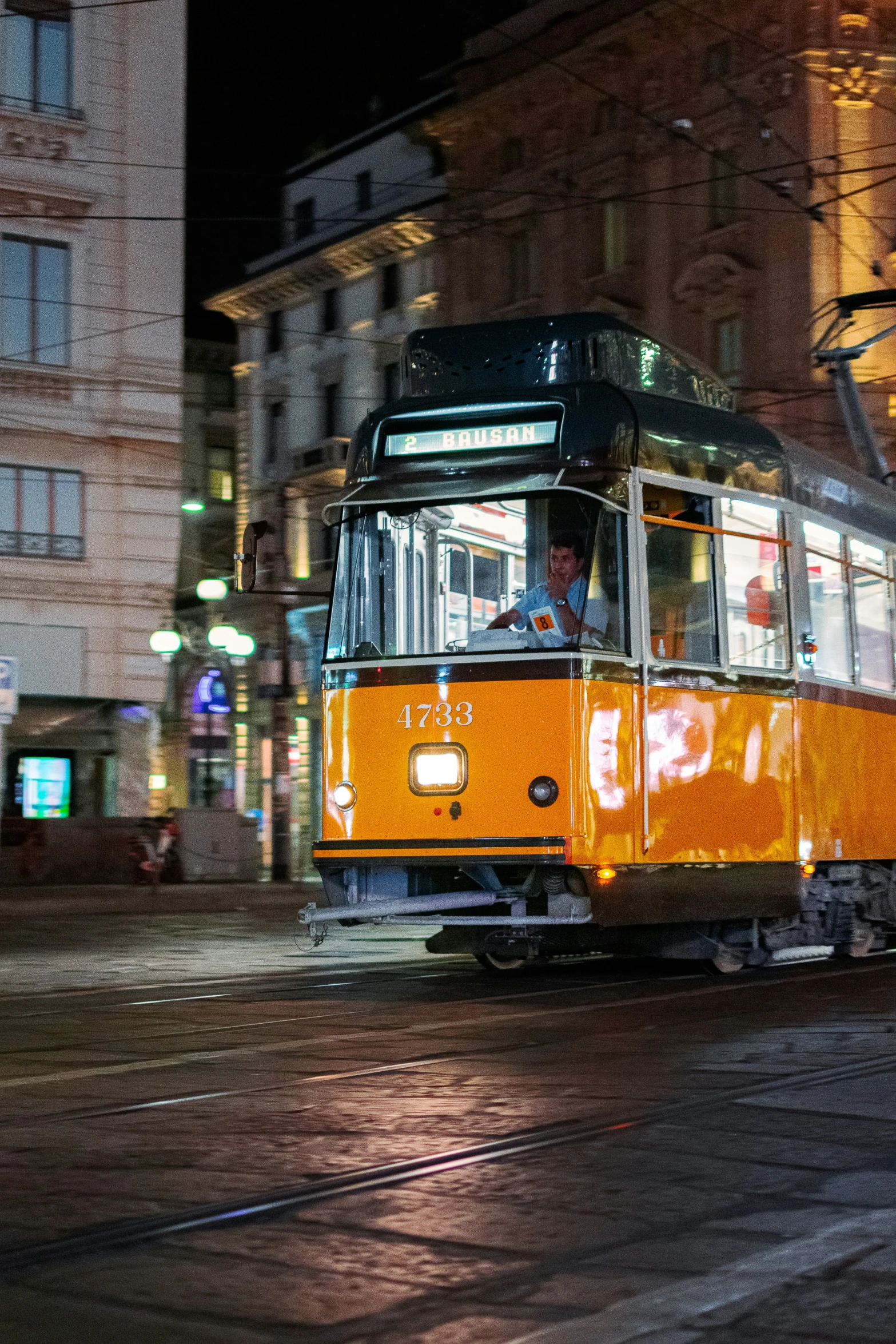 a trolly car with a large window is going on the street