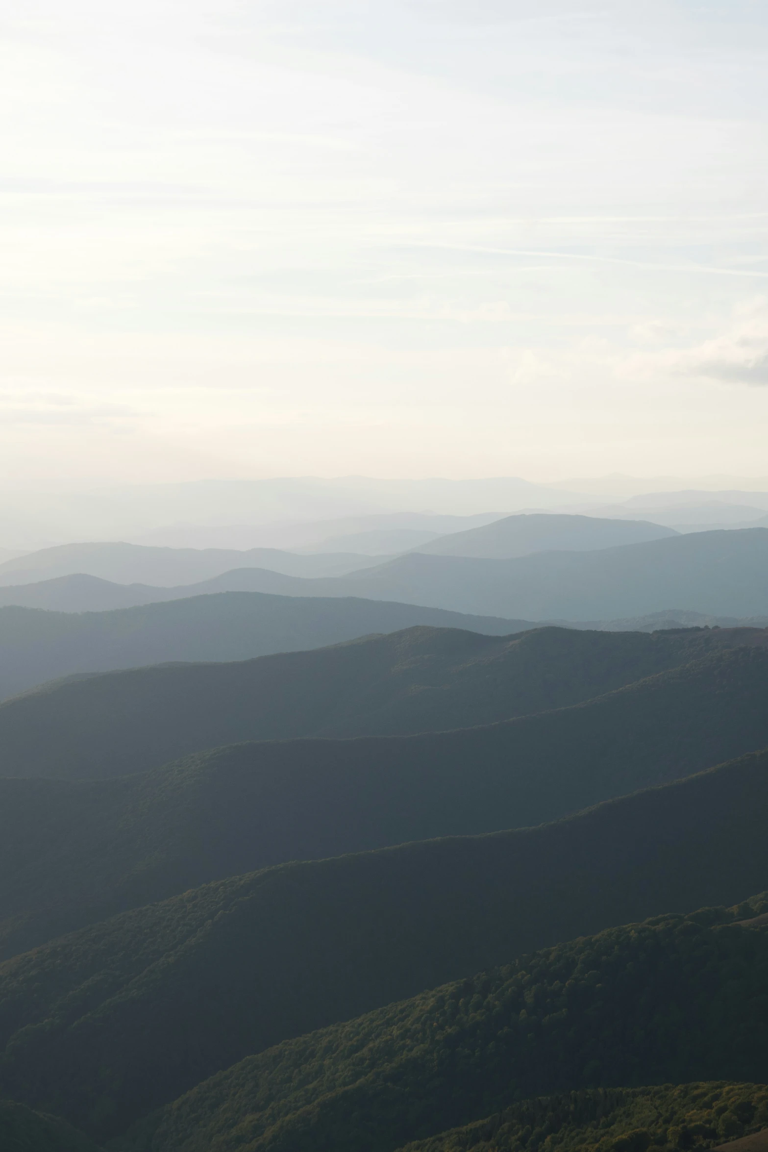 a distant landscape with hills and grass in the foreground