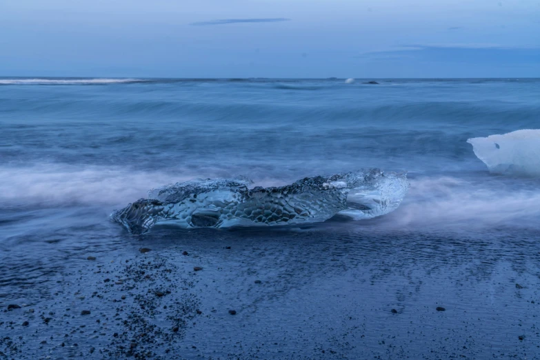 an iceberg floating on top of the ocean near some beach