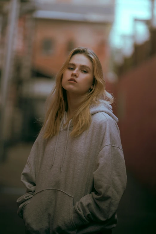 a young woman looks up in the sky while wearing a hoodie