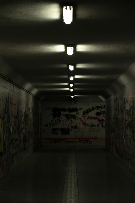 a very long dark and graffiti covered tunnel