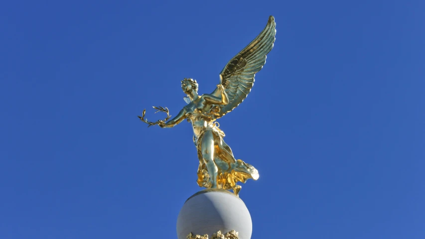the golden statue is on top of the pole