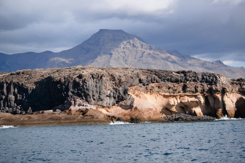 a mountain is on a cliff out in the ocean