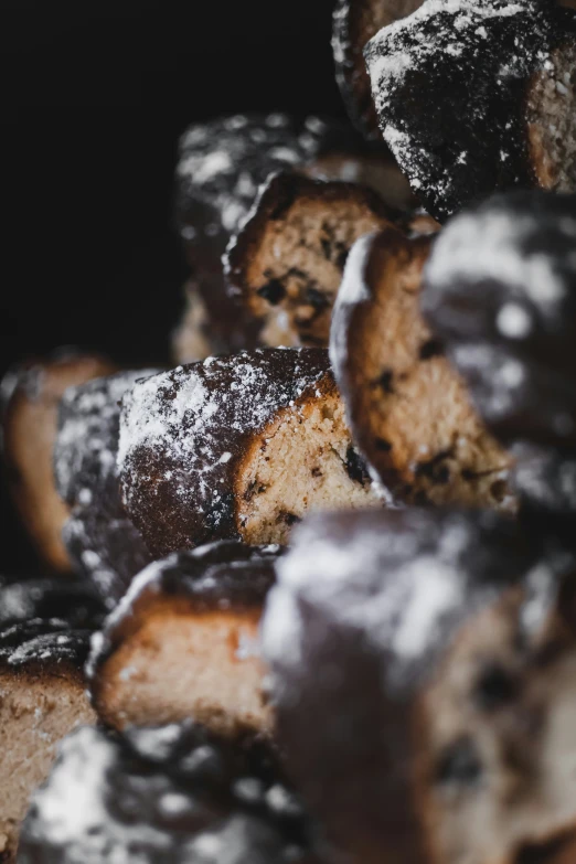 some sugared pastries piled together with one piece eaten