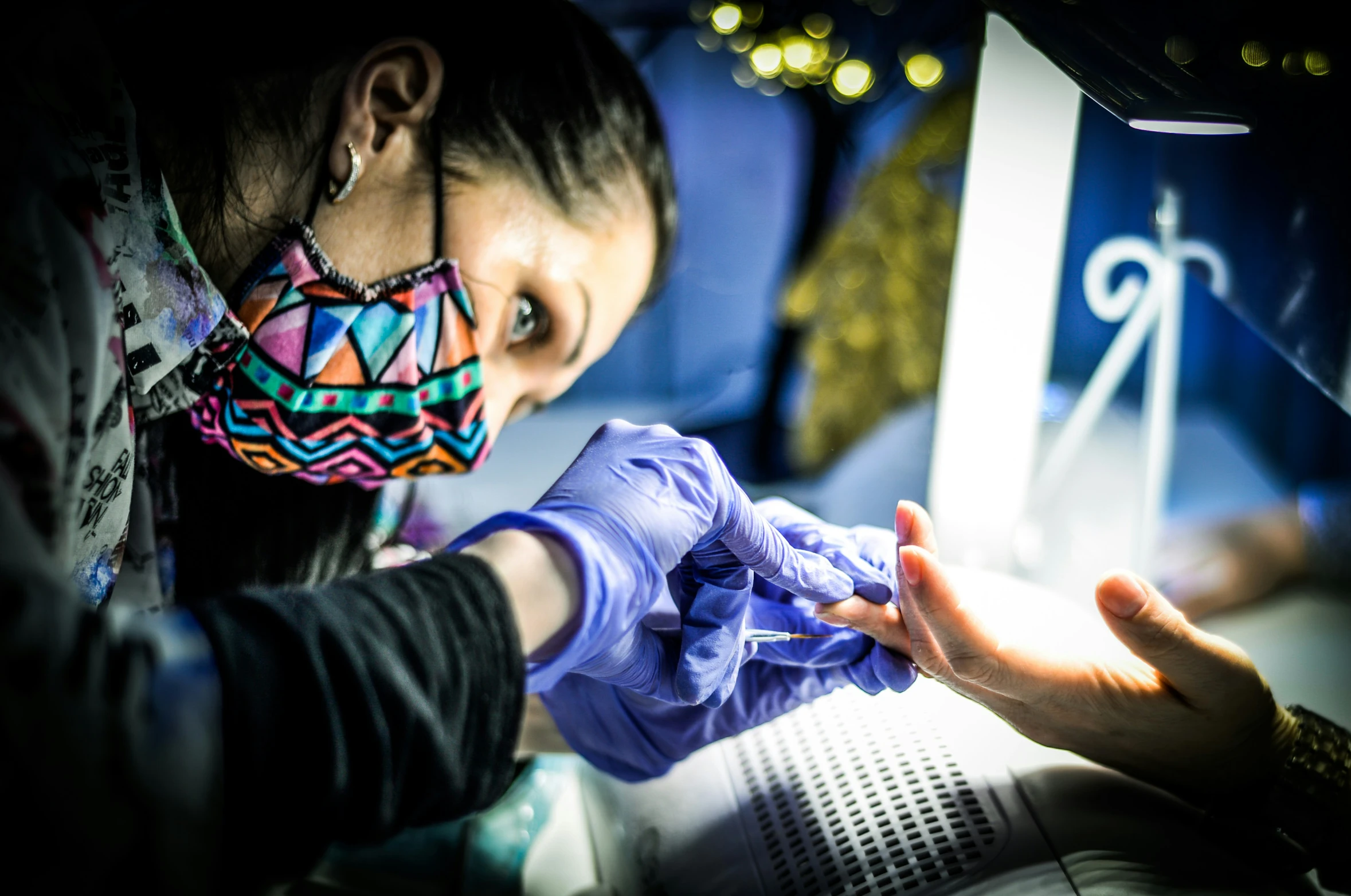 a woman wearing a face mask looking at soing in her hand