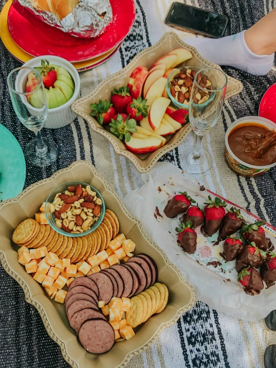 a picnic table full of snacks, fruit and dips