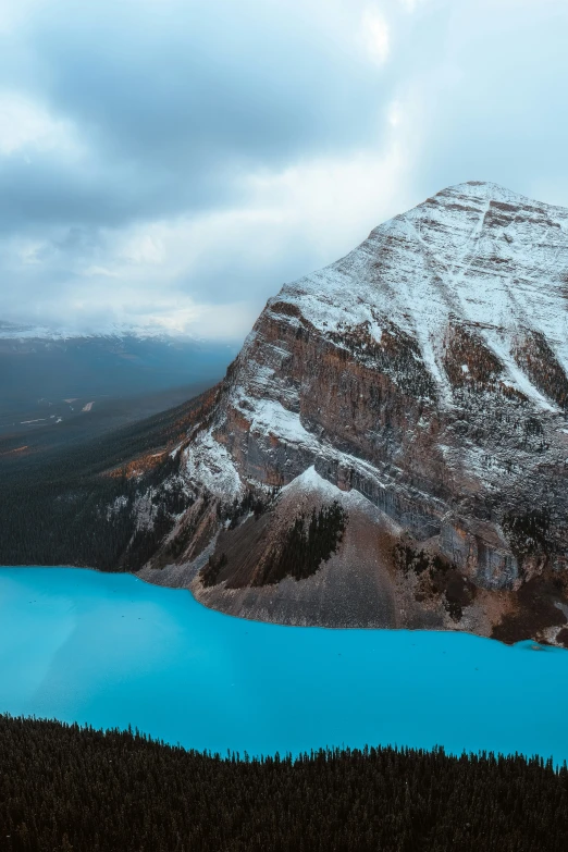 a snowy mountain sits above a lake