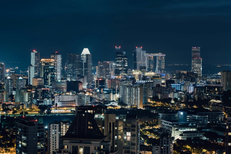 city skyline at night with lights of skyscrs in the background