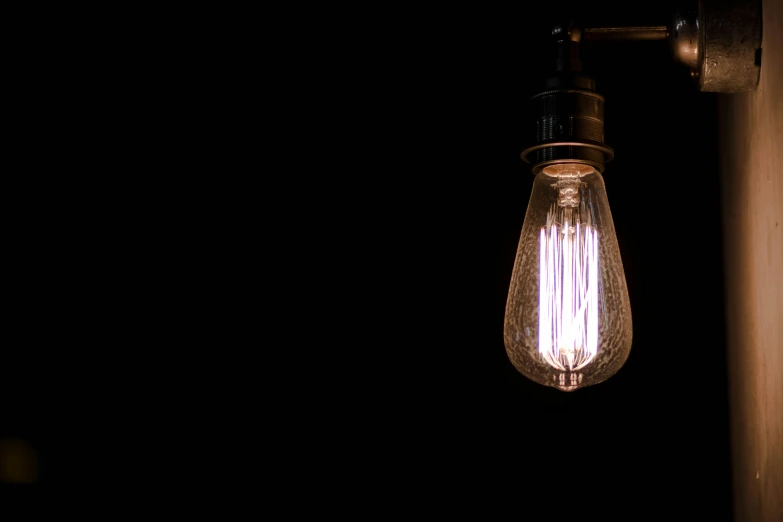 an old fashioned wall light bulb hanging on the wall