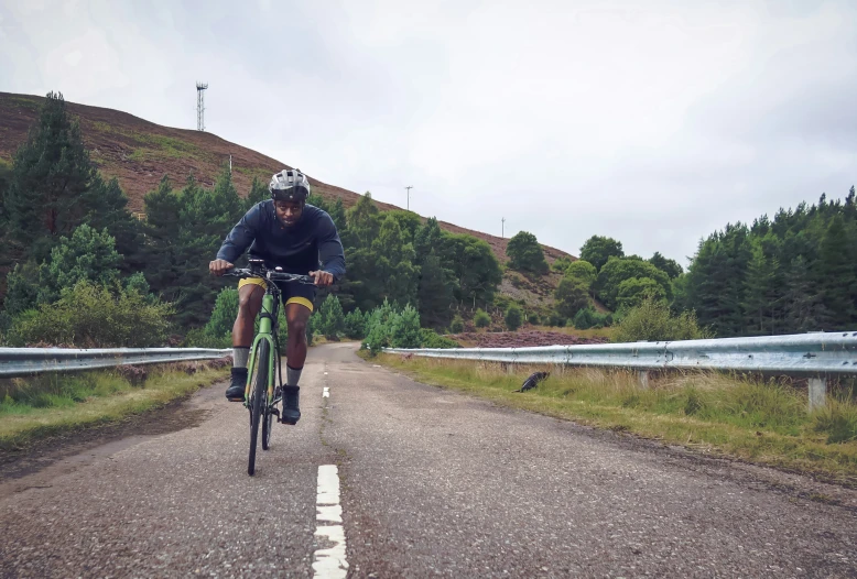 a man riding a bike down the middle of a road