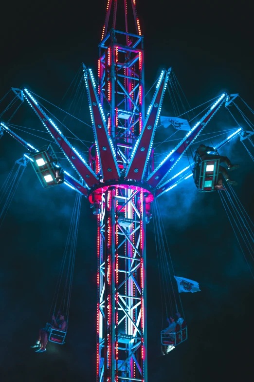 a very tall ferris wheel with lights in the dark