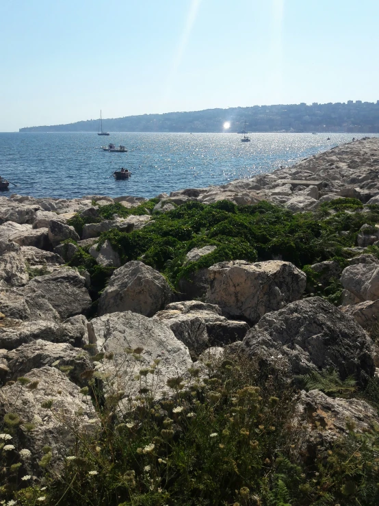 a large rocky beach with a small boat on it