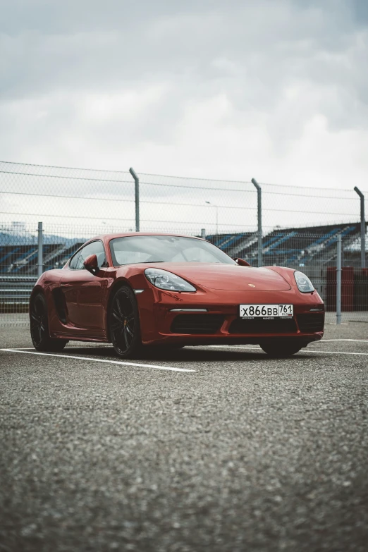 a red sports car is on a gravel road