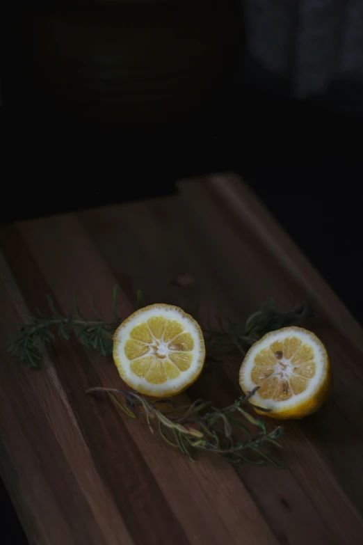 two oranges cut in half on top of a  board