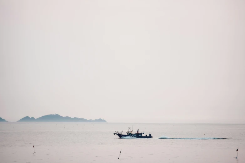 a fishing boat on a foggy day off the coast