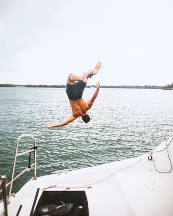 a man is jumping from a boat into the water