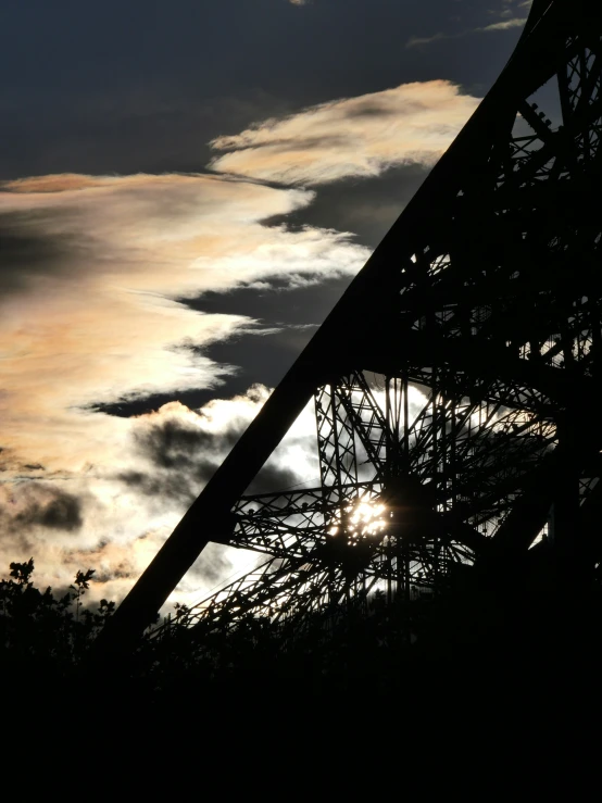 silhouette of a building with the sun breaking through the clouds