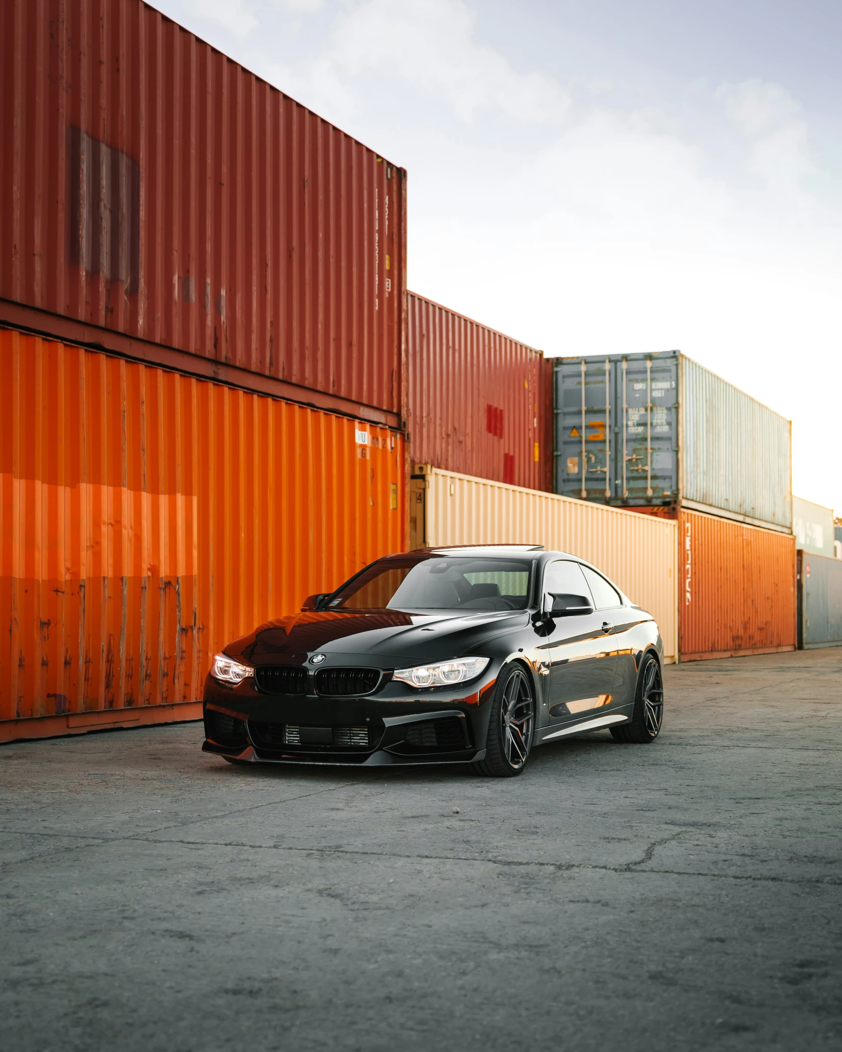 black car parked in front of some orange containers