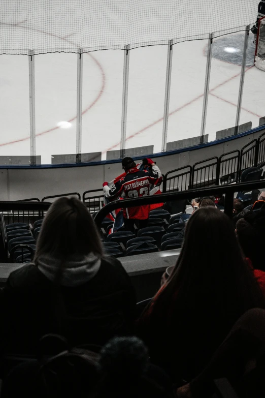 two men standing in the middle of an empty hockey arena