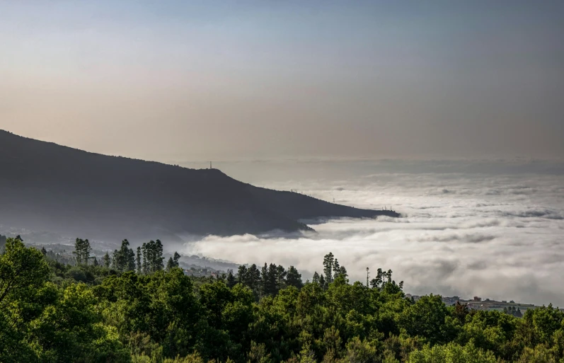 an aerial view of the ocean with some low clouds