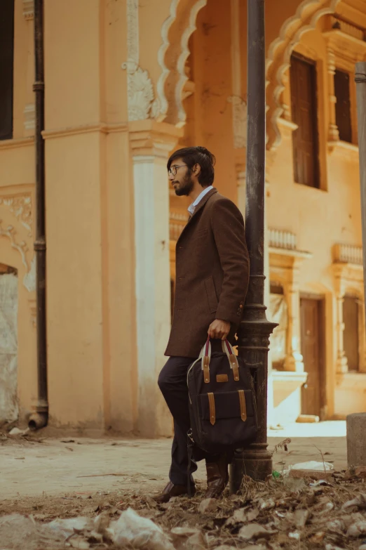 a man standing next to a pole holding a brief case