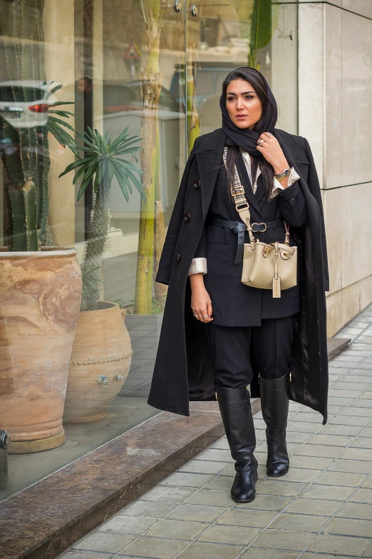 a woman wearing black is standing outside in front of a window