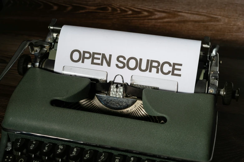 open source typewriter with paper next to it on a table