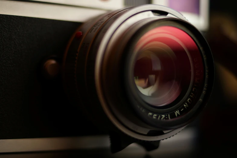 a camera with its lens up close and some blurry images in the background