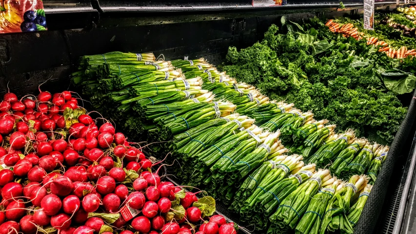 an arrangement of green, red and purple fruits and vegetables