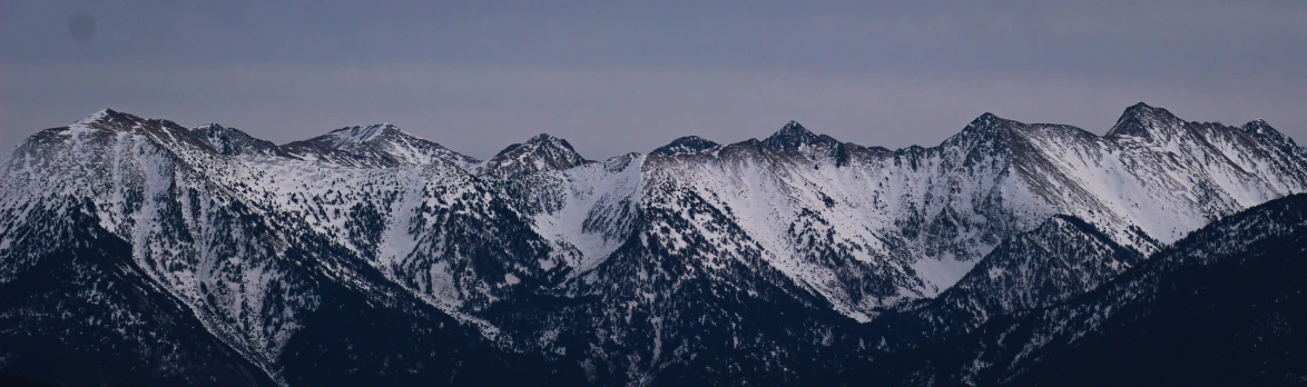 several snow capped mountains with a blue sky