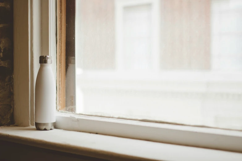 an empty white vase sitting on a window sill