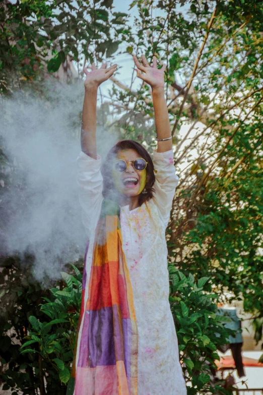 a woman poses in front of colorful paint