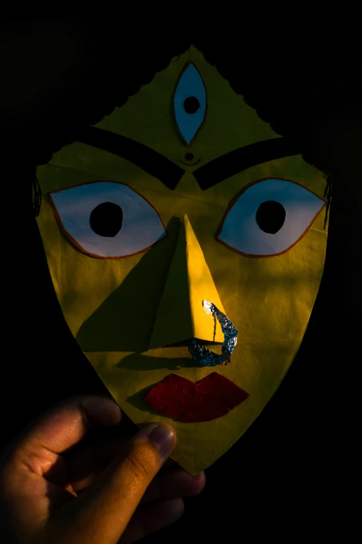 someone holds up their face with the shape of a mask