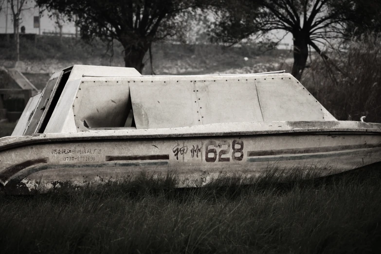 an old boat lying in the grass at a park