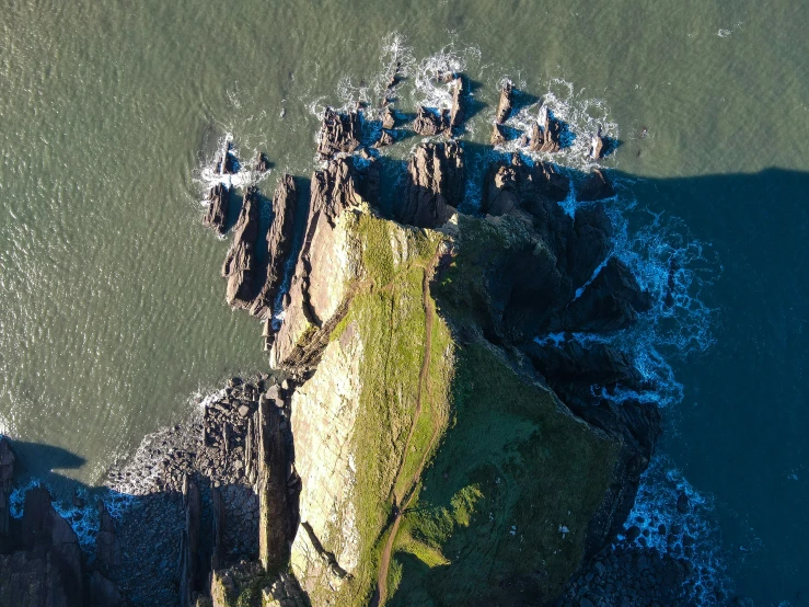 aerial view of water with rocky shore on sunny day