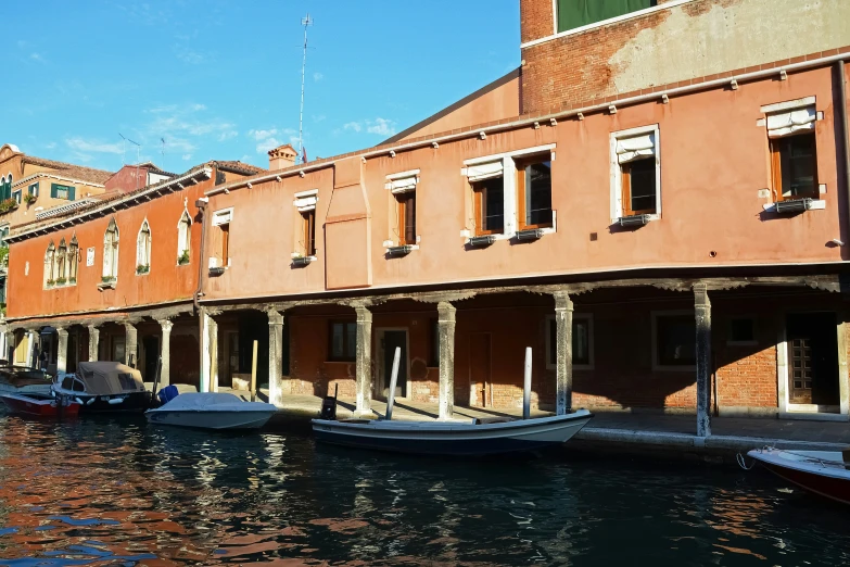 a canal filled with lots of boats next to tall buildings