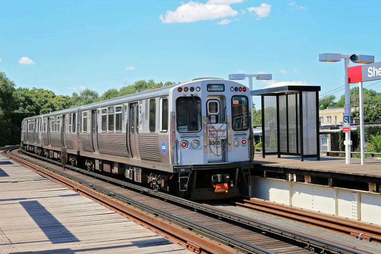 a silver and white train traveling on railroad tracks