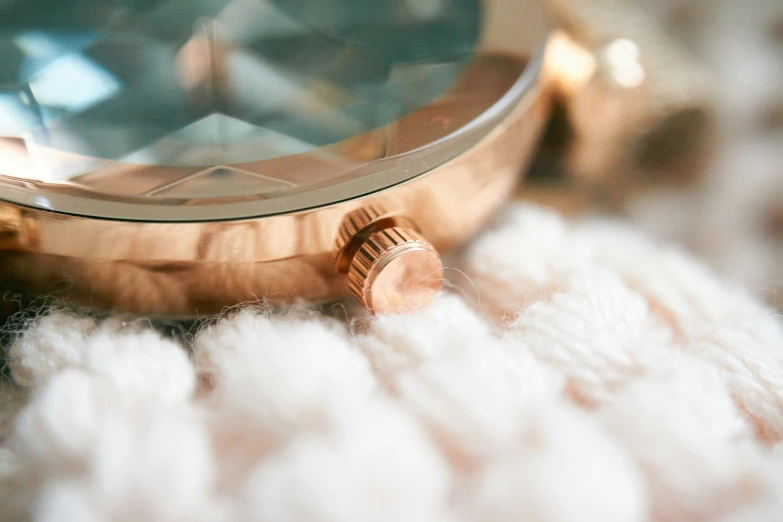 a wrist watch sitting on top of a white blanket